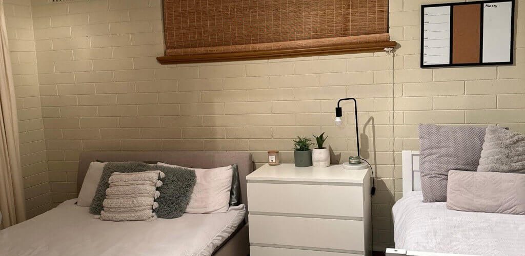 Bed with white bedsheet beside a table